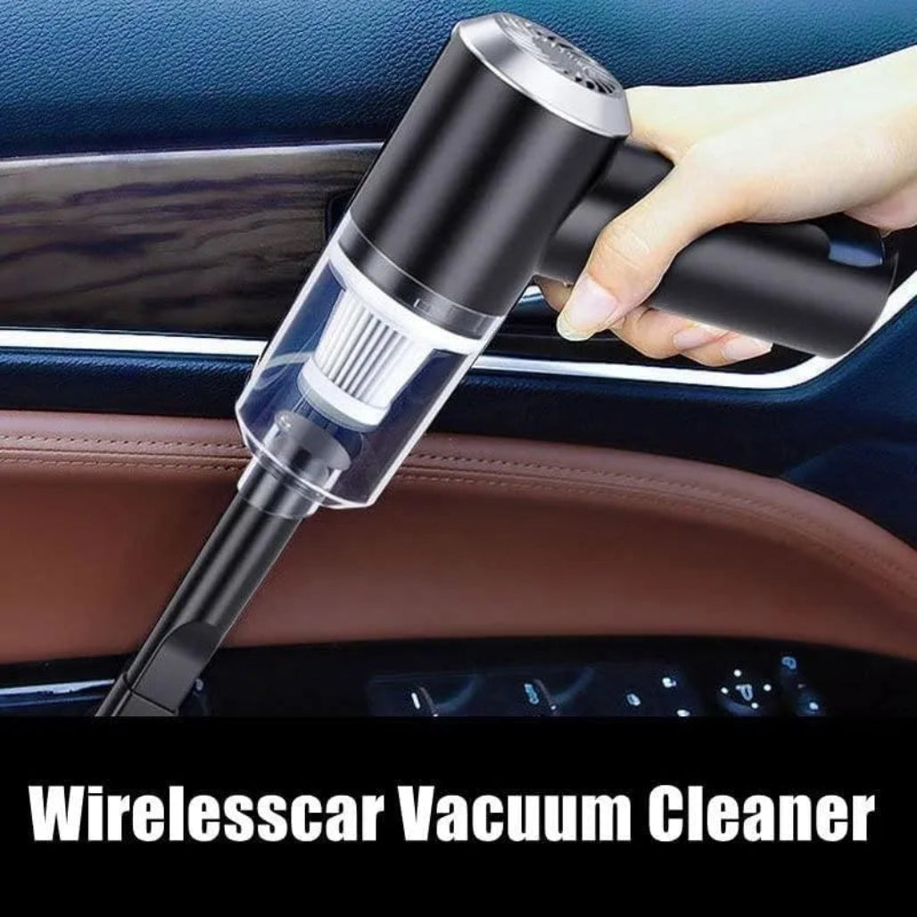 Hand holding a wireless car vacuum cleaner inside a vehicle.