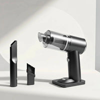 Silver handheld vacuum cleaner with attachments on a light gray background